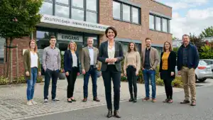 Chefin mit ihrer Belegschaft vor der Firma